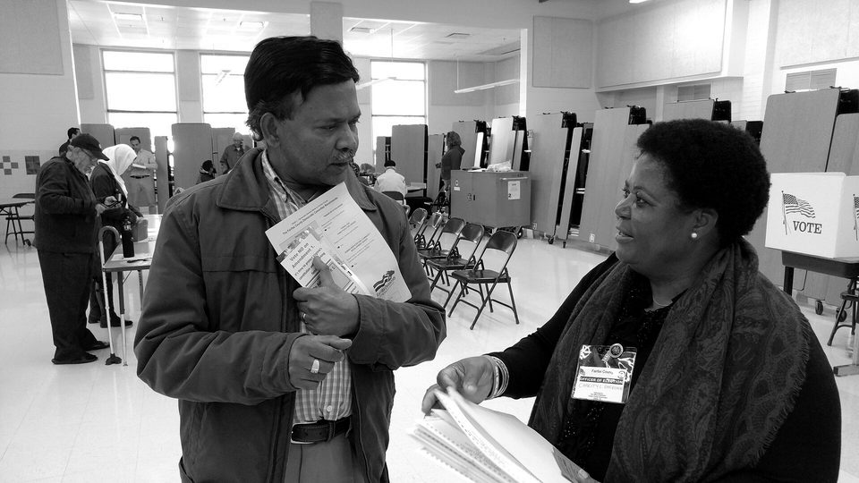 Virginia voter gets election materials from polling station worker before voting in US presidential election, Nov. 8, 2016